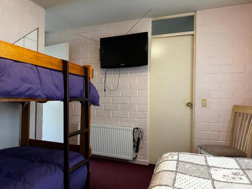 a bedroom with a bunk bed and a flat screen tv at Cerca Aeropuerto Ruta 5 Sur, 2 estacionamientos, capacidad 8 personas in Puerto Montt