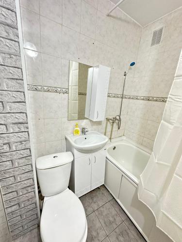 uma casa de banho com um WC, um lavatório e uma banheira em Однокомнатная квартира Шалкыма em Atyrau