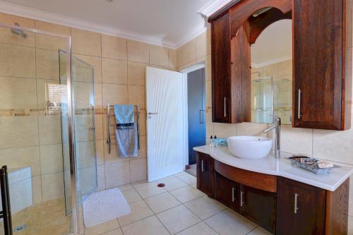 a bathroom with a sink and a glass shower at Belle Vue Suite in Wilderness