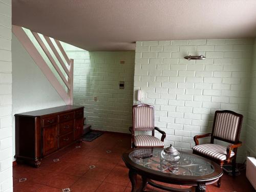 a room with two chairs and a table and a cabinet at Cerca Aeropuerto Ruta 5 Sur, 2 estacionamientos, capacidad 8 personas in Puerto Montt