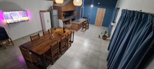 eine Küche mit einem Tisch und Stühlen sowie einem TV in der Unterkunft Quinta Loma Hermosa in Diamante