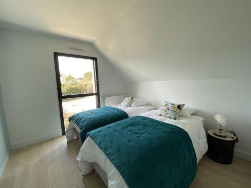 2 camas en una habitación con ventana en LE BEC - Maison 6 personnes - La Trinite-sur-Mer en La Trinité-sur-Mer