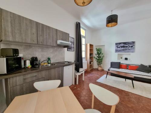 une cuisine et un salon avec une table et des chaises dans l'établissement Studio centre historique 1, à Aix-en-Provence