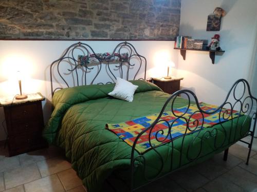 a bedroom with a green bed with two lamps at La tana delle coccinelle in Capracotta