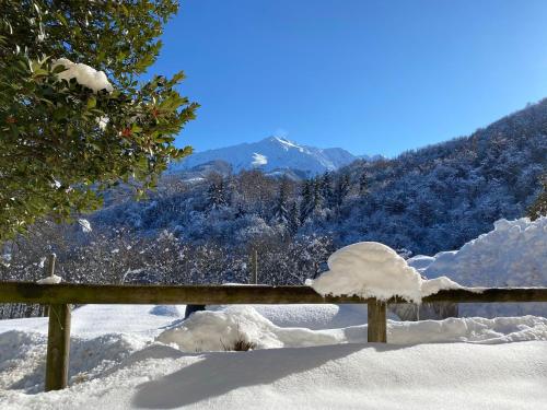 a bench covered in snow with a mountain in the background at Ranch Enbrucà in Boves