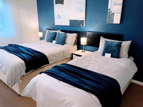 twee bedden in een kamer met blauwe muren bij Aspen House in Birmingham