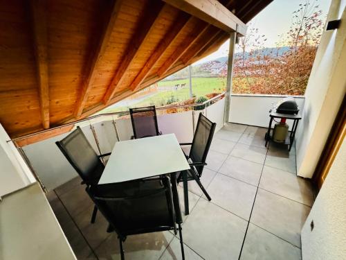 a patio with a table and chairs on a balcony at Landloft in Oberteuringen