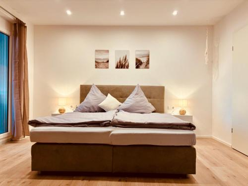 a bed in a bedroom with two pictures on the wall at Landloft in Oberteuringen
