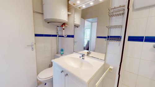 une salle de bain avec un lavabo, des toilettes et un miroir dans l'établissement Bulle O 50 m de la plage, à Saint-Gilles-Croix-de-Vie