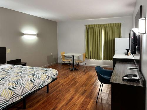 a room with a bed and a table and a desk at Studio 6 Suites Springfield, OH in Springfield