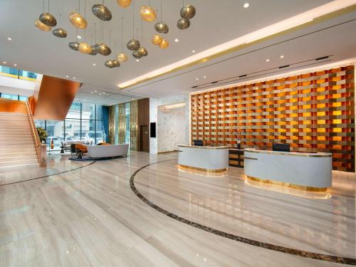 a lobby of a hotel with two reception desks at Mövenpick Living West Hanoi in Hanoi
