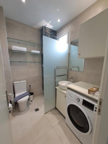 a bathroom with a washing machine and a toilet at paris villas in Mitika