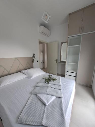 a bedroom with a white bed with towels on it at paris villas in Mitika