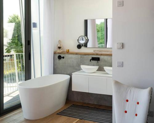 a white bathroom with a tub and a sink at 3BR Gem, 8 Min Drive to Bicester Village in Bicester