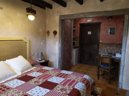 1 dormitorio con cama, mesa y baño en H&AP Rural Merrutxu en Ibarrangelu