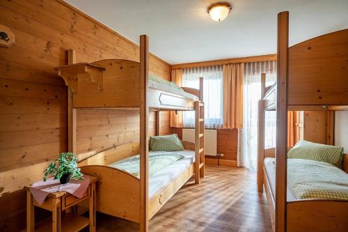 two bunk beds in a room with wooden walls at Berggasthof Rofan in Maurach