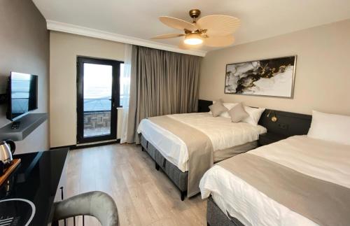 um quarto de hotel com duas camas e uma televisão de ecrã plano em Elif Otel em Ereğli