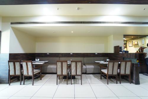a dining room with chairs and tables in a restaurant at Dvr Mansion in Kurnool