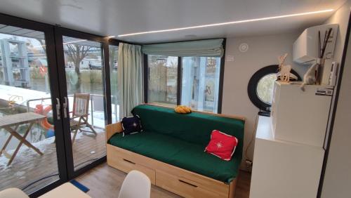 ein Wohnzimmer mit einem grünen Sofa und einem Kühlschrank in der Unterkunft Houseboat Water Boy apartament pływający dom na wodzie łódź in Breslau