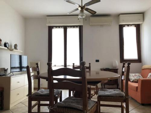 ein Wohnzimmer mit einem Tisch und Stühlen sowie einem Deckenventilator in der Unterkunft Appartamento comodo per brevi periodi in Forlì