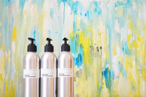 three silver bottles sitting next to a painting at Apartment Hotel Shinjuku in Tokyo