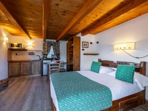 Un dormitorio con una cama grande en una habitación con techos de madera. en Studio Ancienne Bergerie Studio 1 - VOU140 by Interhome, en Valtournenche