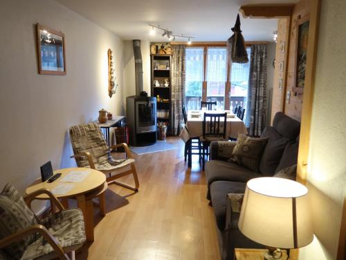 sala de estar con sofá, sillas y mesa en Apartment Val Neige by Interhome en Les Diablerets