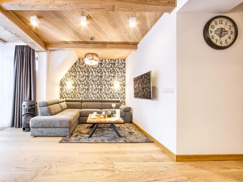 een woonkamer met een bank en een tafel bij VisitZakopane - Chalet Ski Apartment in Zakopane