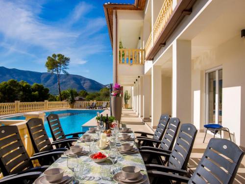 a table and chairs on a patio with a pool at Villa Villa Cara Mull Alcalalí by Interhome in Alcalalí