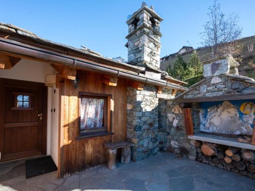 a stone building with a wooden door and a chimney at Studio Ancienne Bergerie Studio 3 by Interhome in Valtournenche