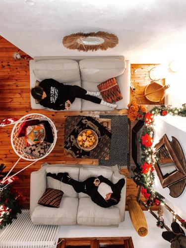 two people laying on a couch in a living room at PANOS PALACE in Pramanta