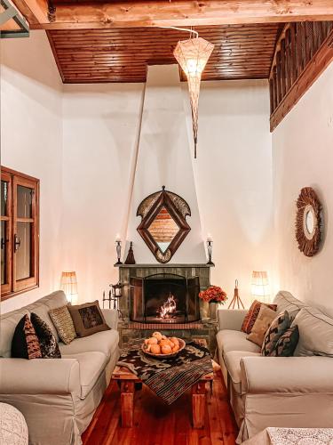 a living room with two couches and a fireplace at PANOS PALACE in Pramanta