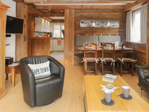 een woonkamer met een leren stoel en een tafel bij Apartment Dianthus-2 by Interhome in Zermatt