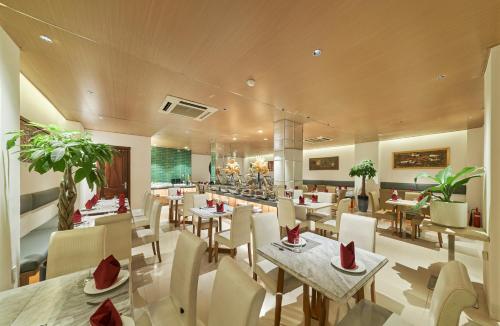 um restaurante com mesas e cadeiras e um bar em Sky Gem Hotel - Ben Thanh em Ho Chi Minh