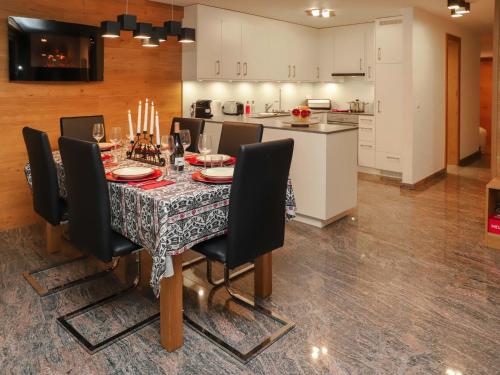a dining room with a table and chairs and a kitchen at Apartment Turquino C by Interhome in Zermatt