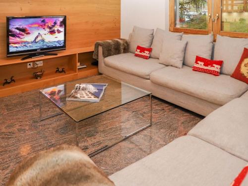 a living room with two couches and a tv at Apartment Turquino C by Interhome in Zermatt