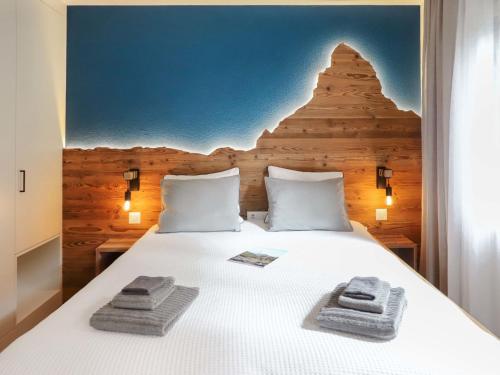 ein Schlafzimmer mit einem Bett mit Handtüchern darauf in der Unterkunft Apartment Papillon by Interhome in Zermatt