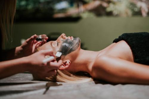 a woman laying on the floor brushing her teeth at Hotel Dębowy Biowellness & SPA Góry Sowie in Bielawa
