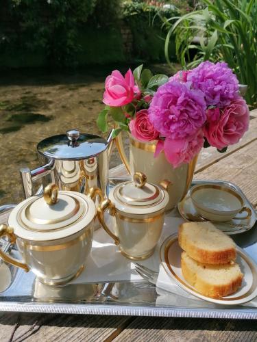 - un plateau/bouilloire et des fleurs sur une table dans l'établissement La Malposte, à Reviers
