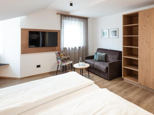 a living room with a bed and a couch at Hotel Blitzburg in Brunico