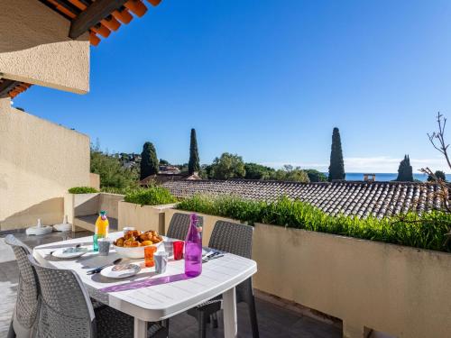 uma mesa branca com uma tigela de comida num pátio em Apartment Les Pescadieres-3 by Interhome em Le Lavandou