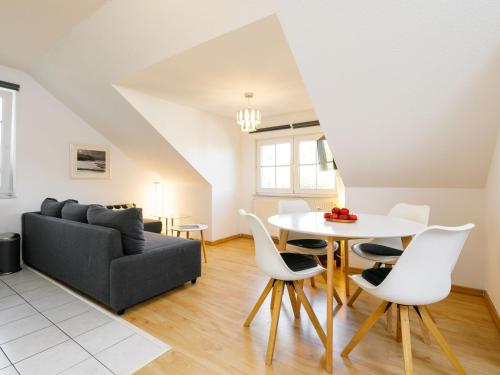 Una sala de estar con un sofá, una mesa y sillas. en Apartment Niewald by Interhome, en Ostseebad Koserow