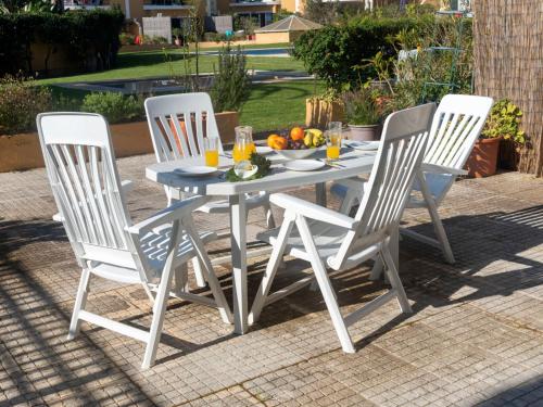 a white table with four chairs and a bowl of fruit at Holiday Home Girassol by Interhome in Cascais