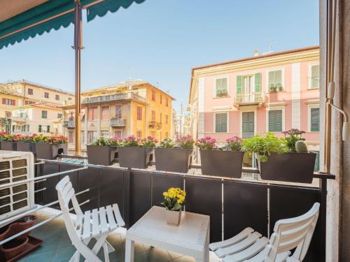 einen Balkon mit weißen Stühlen, Tischen und Blumen in der Unterkunft Studio Blu by Interhome in Rapallo