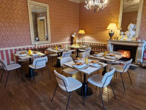 a restaurant with tables and chairs and a fireplace at Château du Pont d'Oye in Habay-la-Neuve
