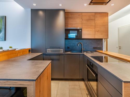 a kitchen with stainless steel appliances and wooden cabinets at Apartment Verditz alpe maritima Ski & See - Top 1 by Interhome in Annenheim