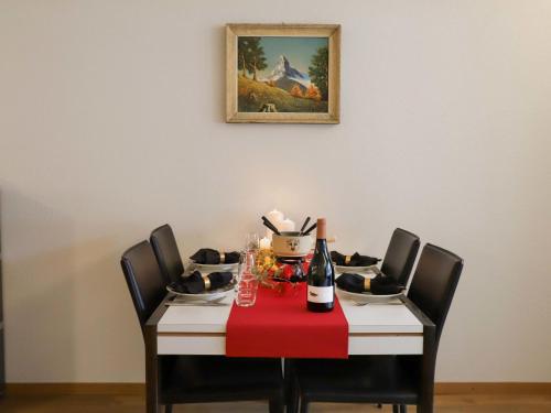 una mesa de comedor con una servilleta roja. en Apartment Pasadena-3 by Interhome en Zermatt