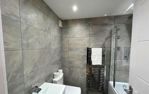 uma casa de banho com um chuveiro, um WC e um lavatório. em London Mitcham Beautifully Presented Two Bedroom Apartment em Mitcham