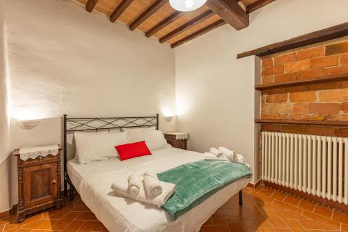 ein Schlafzimmer mit einem Bett mit einem roten Kissen in der Unterkunft Appartamento Aria - Capolinea in Castiglione del Lago