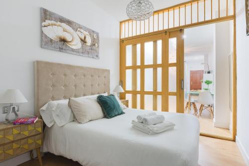 a bedroom with a large white bed with towels on it at Malagaflat City Center in Málaga